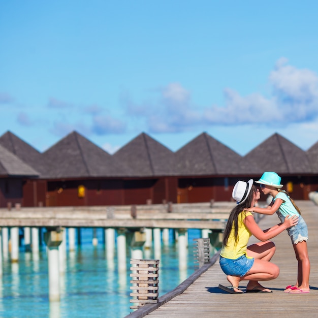 Niña y joven madre durante vacaciones en la playa