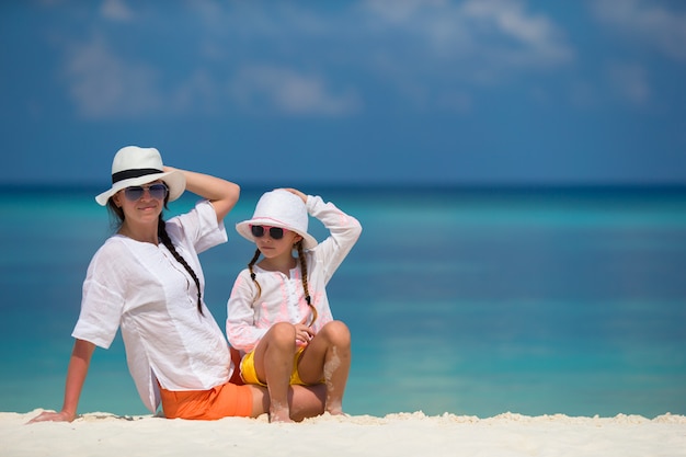 Niña y joven madre durante vacaciones en la playa