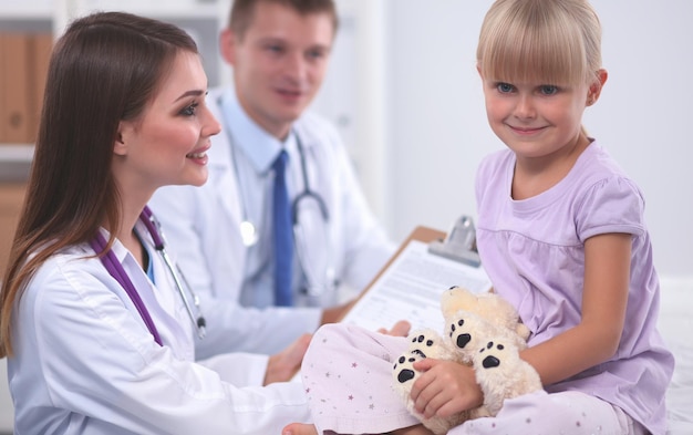 Foto niña y joven médico en el hospital con examen