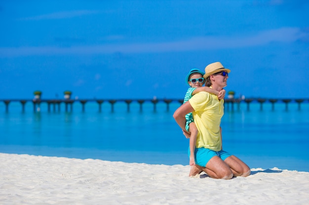 Niña y joven padre durante vacaciones en la playa tropical