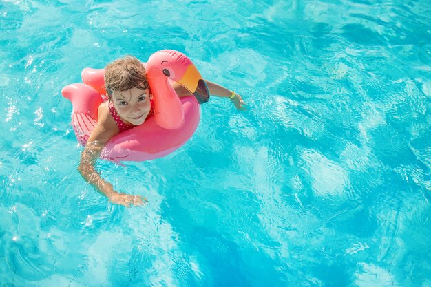 Niña joven, relajante, en la piscina