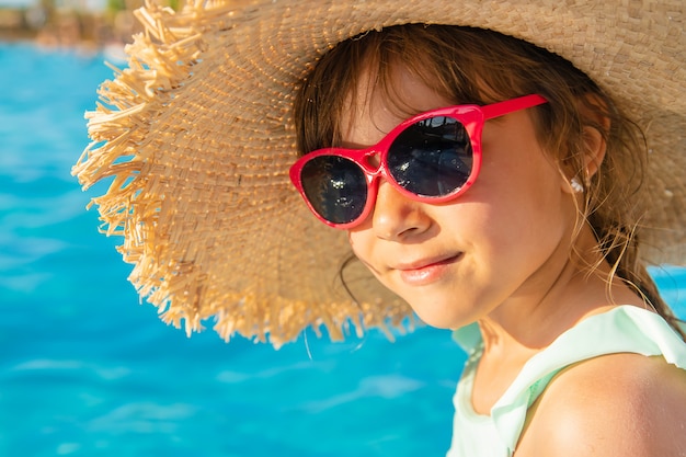 Niña joven, relajante, en la piscina