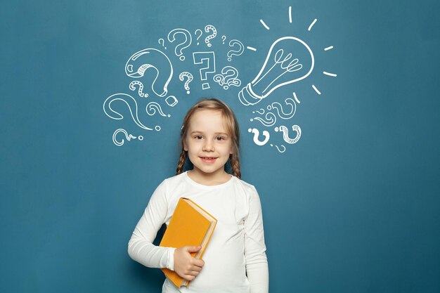Niña joven con signo de interrogación y bombilla idea duda tormenta de ideas y concepto de creatividad