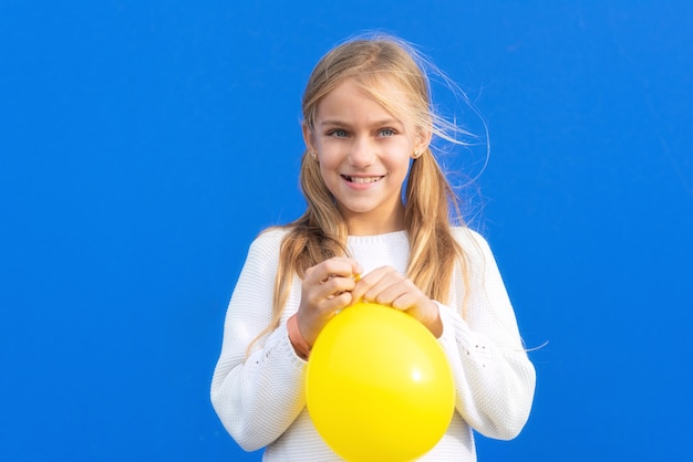 Niña joven, tenencia, globo amarillo