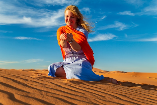 Niña juega con arena en el desierto del Sahara. Erg Chebbi, Merzouga, Marruecos.