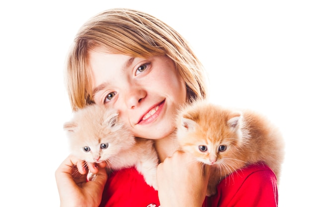 Niña juega con dos gatitos sobre sus hombros