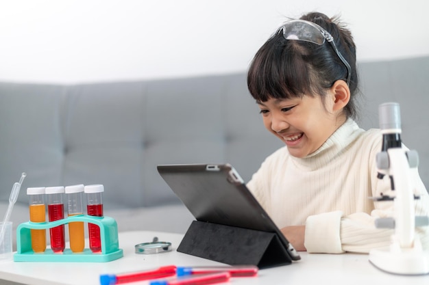 Niña juega experimentos científicos para educación en el hogar