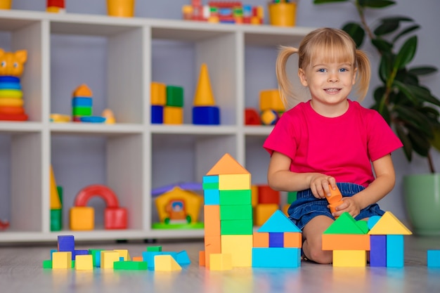 La niña juega con juguetes en casa, en la guardería o guardería. Desarrollo infantil.