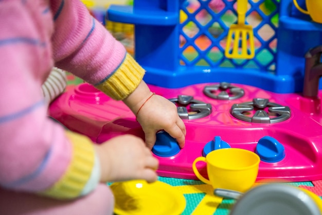 Niña juega con juguetes de cocina de plástico