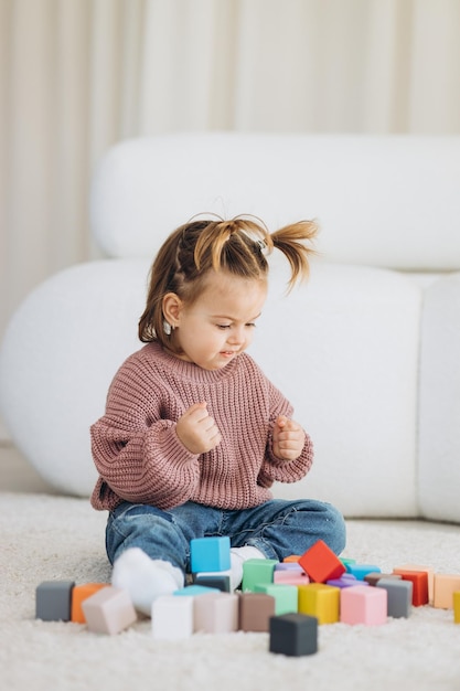 Niña juega juguetes en la sala de estar Juguete de madera Montessori pirámide doblada Círculo triángulo rectángulo elementos de madera de juguetes para niños juguete de color azul amarillo rojo verde