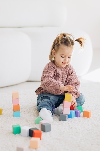 Niña juega juguetes en la sala de estar Juguete de madera Montessori pirámide doblada Círculo triángulo rectángulo elementos de madera de juguetes para niños juguete de color azul amarillo rojo verde