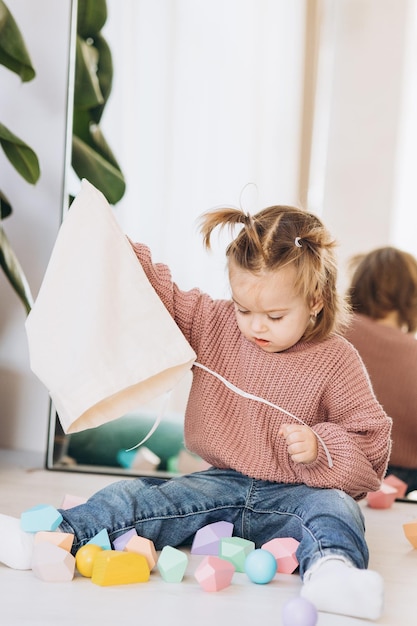 Niña juega juguetes en la sala de estar Juguete de madera Montessori pirámide doblada Círculo triángulo rectángulo elementos de madera de juguetes para niños juguete de color azul amarillo rojo verde