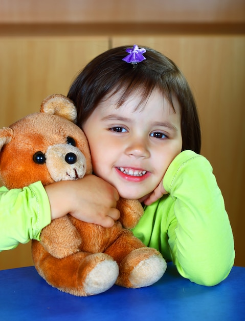 Niña juega con un oso de peluche