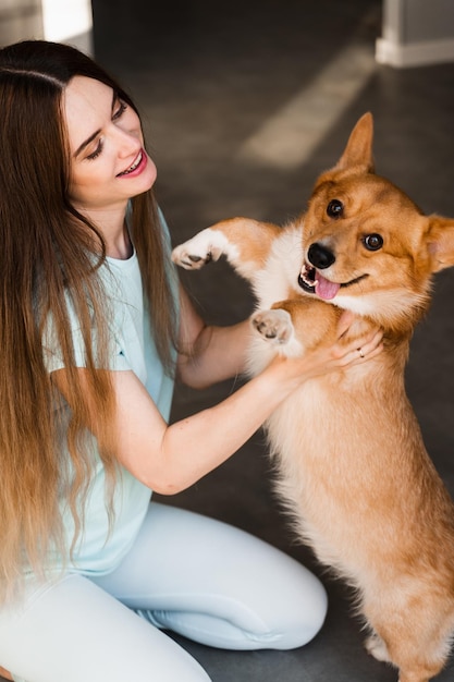 Niña juega con el perro Corgi en casa y se divierte Juguetón Welsh Corgi Pembroke Estilo de vida con mascota doméstica