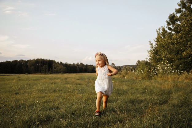 Foto niña juega en el verano en un paseo. huye