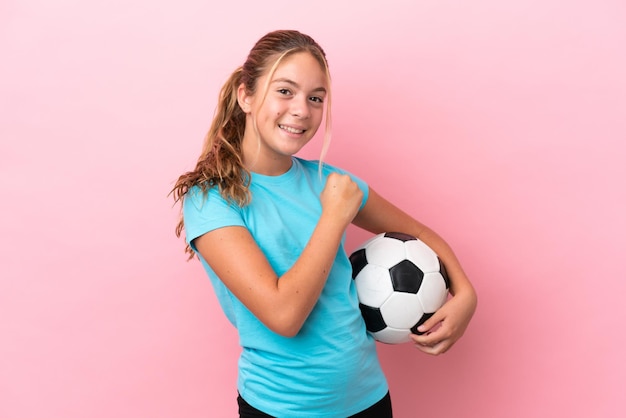 Niña de jugador de fútbol aislada sobre fondo rosa celebrando una victoria