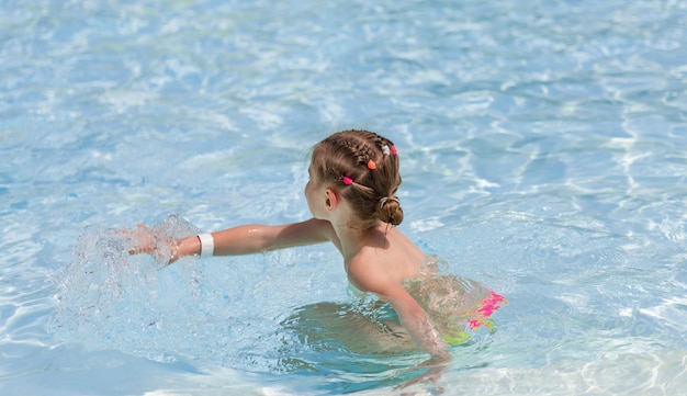 Niña jugando en agua transparente