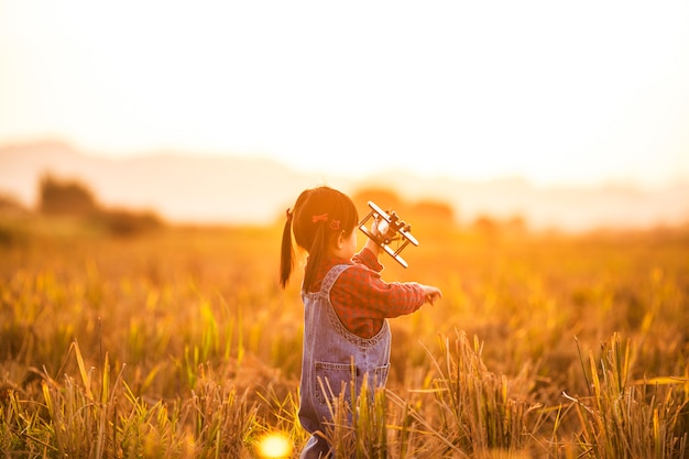 Una niña jugando al aire libre, concepto de vuelo libre