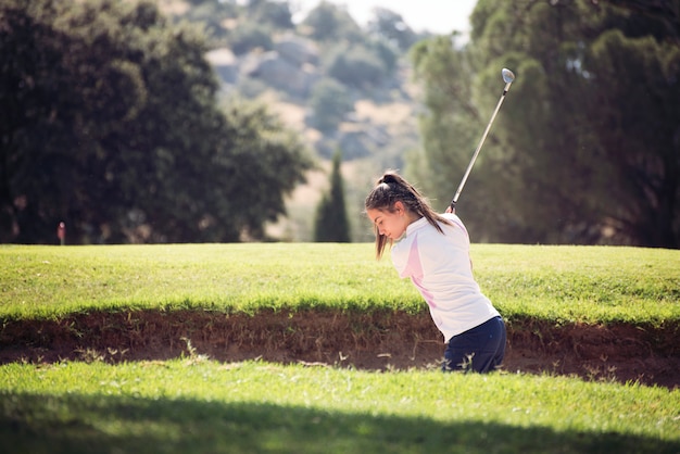 Foto niña jugando al golf en un día soleado