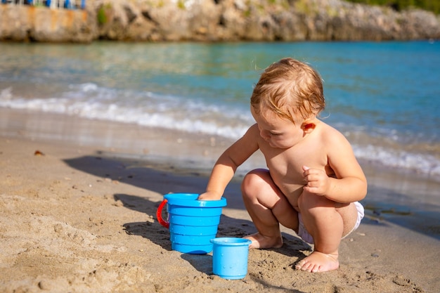 Niña jugando con arena en la playa disfrutando de unas hermosas vacaciones