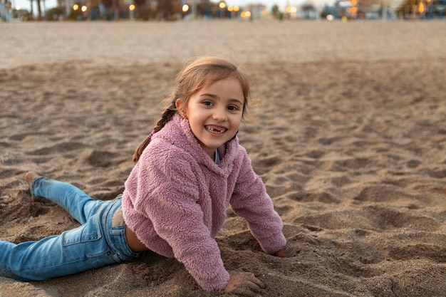 Foto niña jugando en la arena