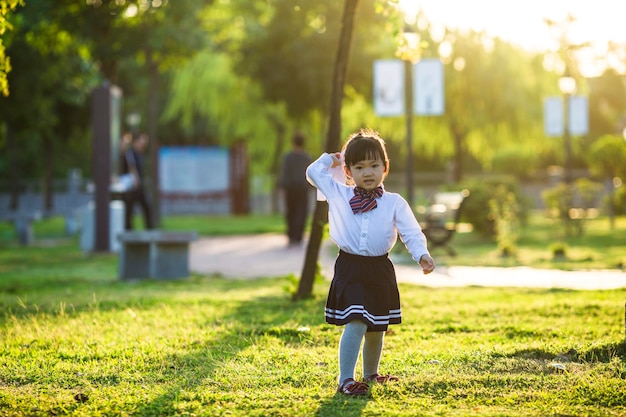 Una niña jugando con un avión de papel en el parque.