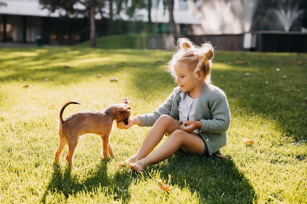 Niña jugando con un cachorro al aire libre