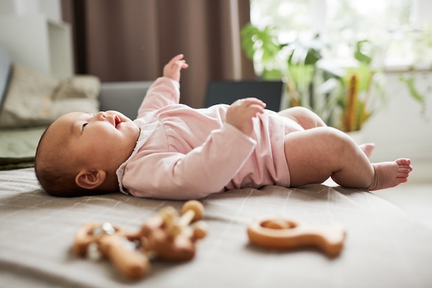 Niña jugando en la cama