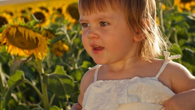 Niña jugando en el campo de girasol.