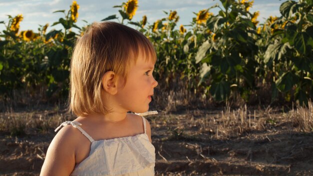 Niña jugando en el campo de girasol.