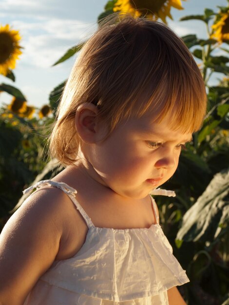 Niña jugando en el campo de girasol.