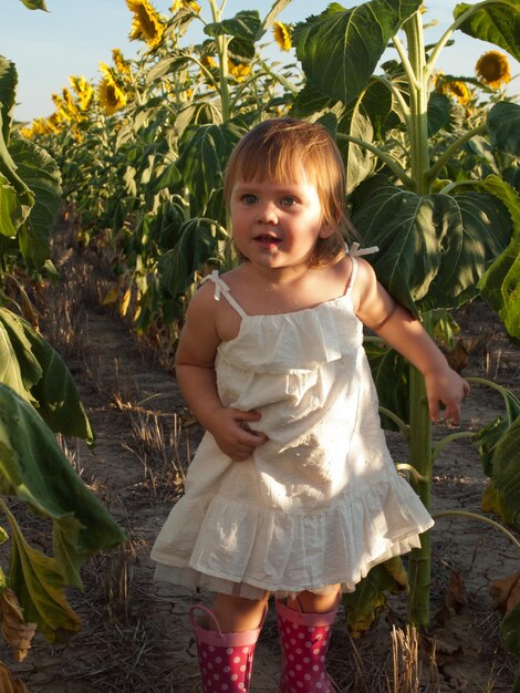 Niña jugando en el campo de girasol.