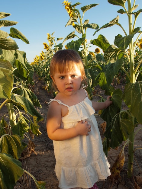 Niña jugando en el campo de girasol.