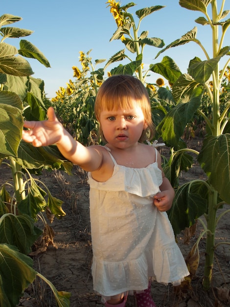 Niña jugando en el campo de girasol.