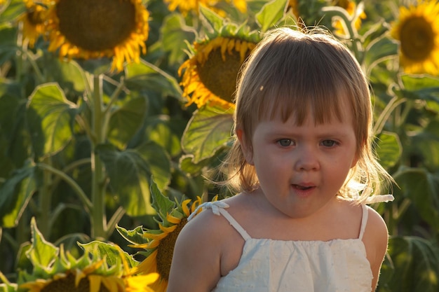 Niña jugando en el campo de girasol.