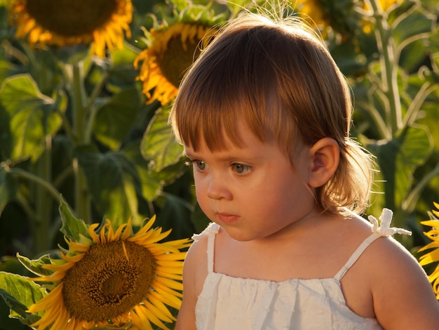 Niña jugando en el campo de girasol.