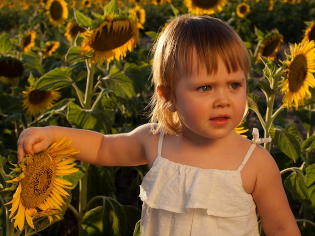 Niña jugando en el campo de girasol.