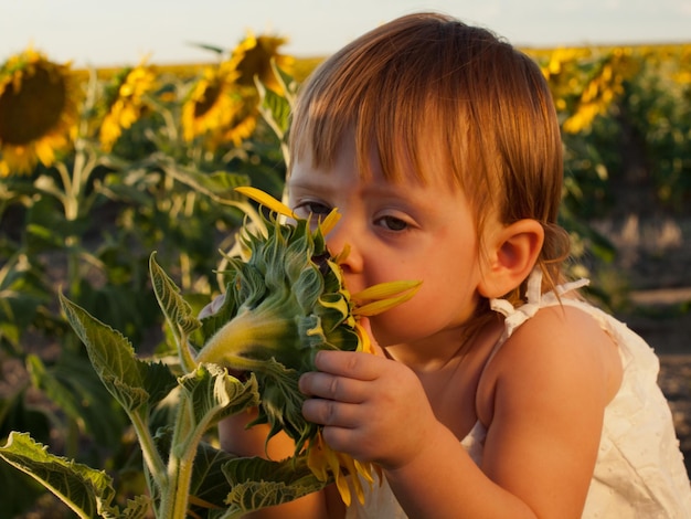 Niña jugando en el campo de girasol.