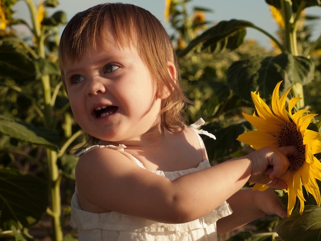 Niña jugando en el campo de girasol.