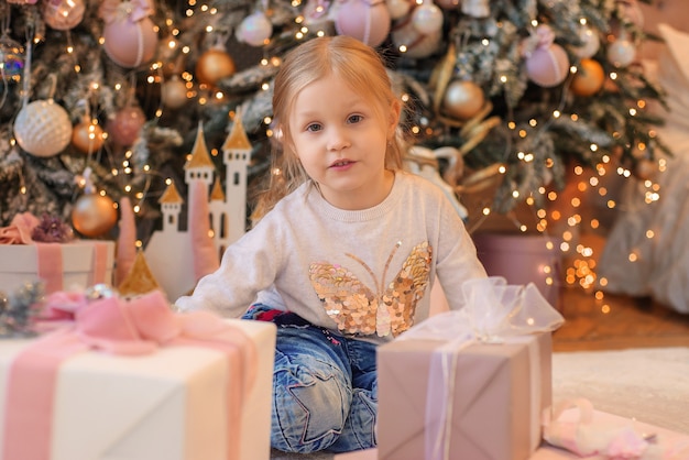 niña jugando cerca del árbol de navidad en navidad