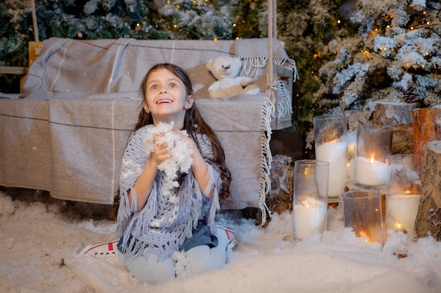 Niña jugando cerca del árbol de navidad