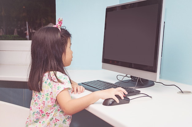 Niña jugando con una computadora