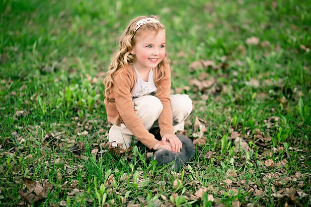 Niña jugando con conejo en el parque