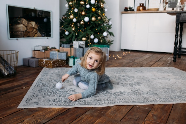 Niña jugando con la decoración de Navidad.