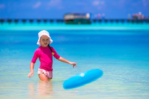 Niña jugando con disco volador en playa blanca