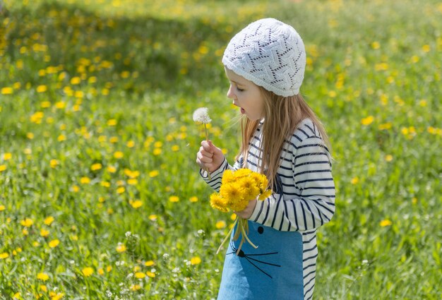 Niña jugando con flores amarillas afuera