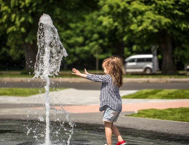 Niña jugando en la fuente