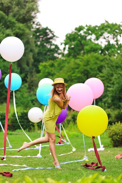 Niña jugando con globos multicolores