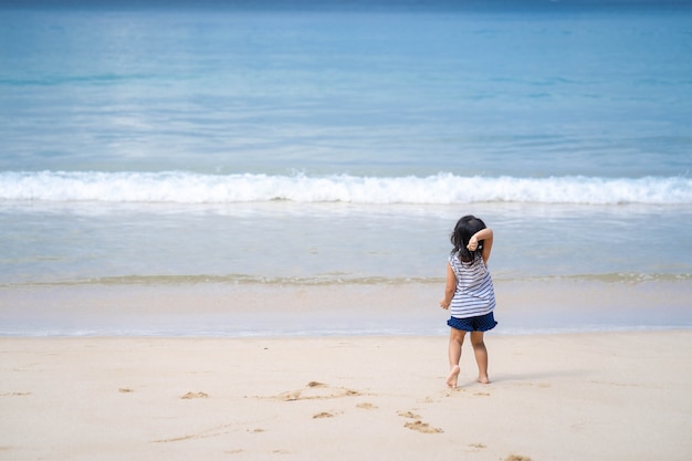 Niña jugando en la hermosa orilla del mar.