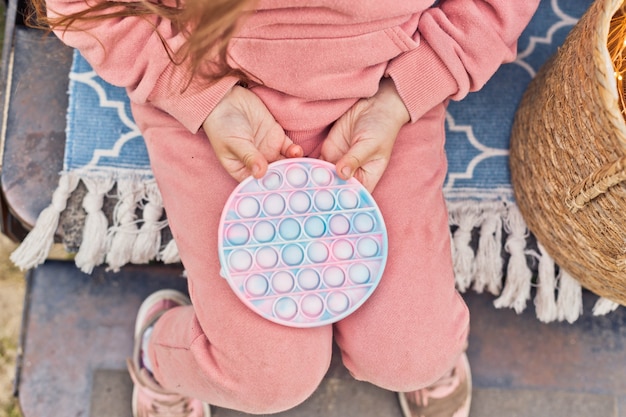 Foto niña jugando con un juguete sensorial de nueva tendencia póngalo en los escalones de un remolque de viaje